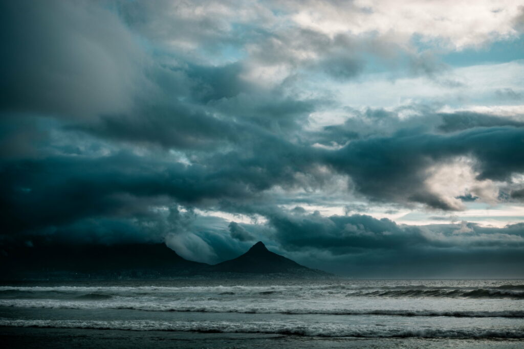 Moody Beach Scene: Tumultuous Waves & Ominous Skies HD Wallpaper