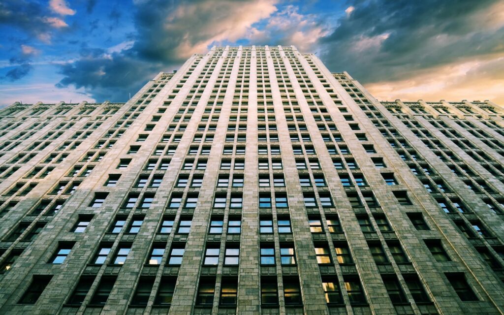 Stunning High-Rise Wallpaper: Upward View with Dramatic Clouds