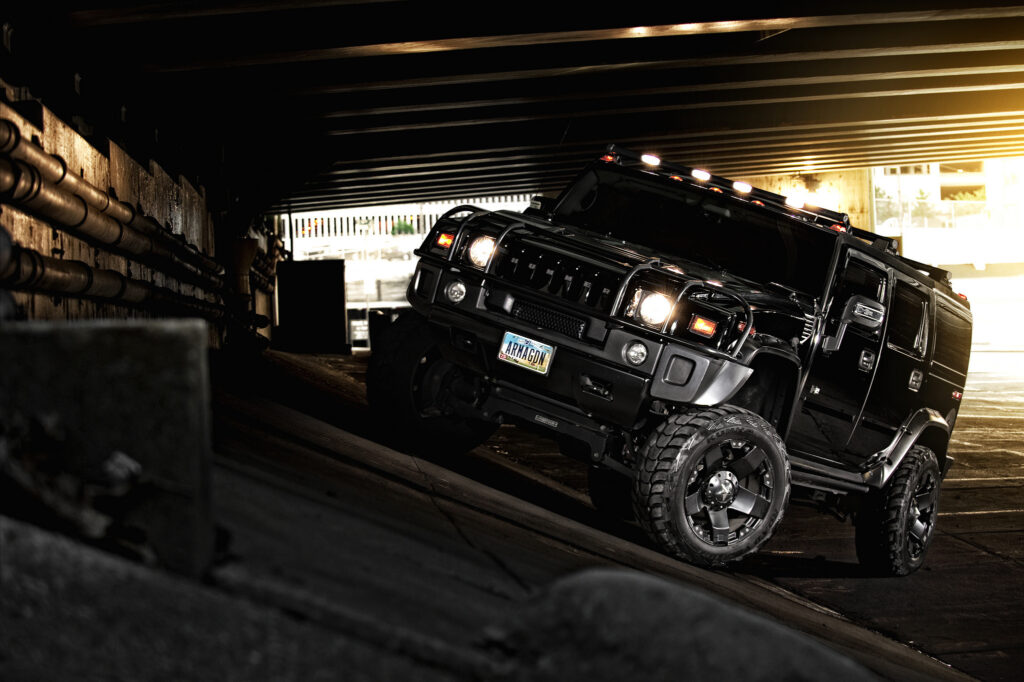 Black Hummer H2 SUV Off-Roading in Rugged Urban Background Wallpaper
