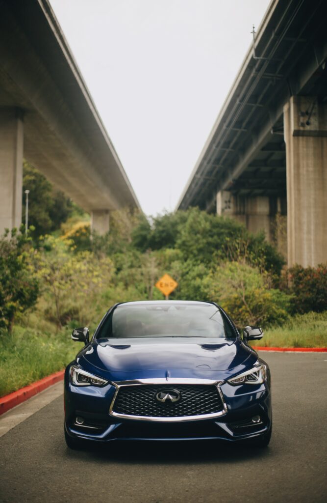Sleek Infiniti Sports Car Wallpaper: Urban Overpass & Nature Blend