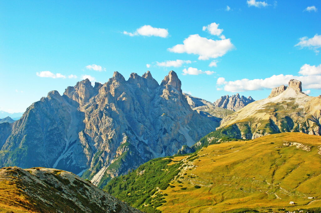 Alps Italy mountain peaks lush green meadows rolling hills vivid blue sky white clouds wallpaper