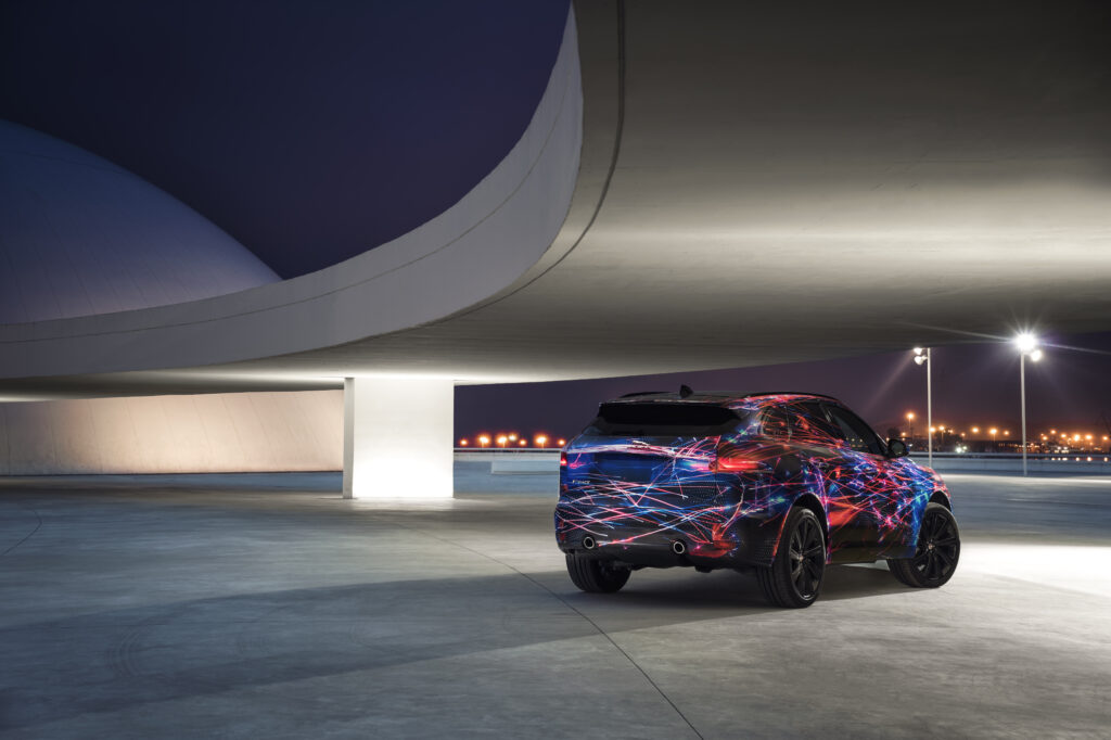 Jaguar F-Pace SUV: Stunning Side View with Modern Architecture Wallpaper