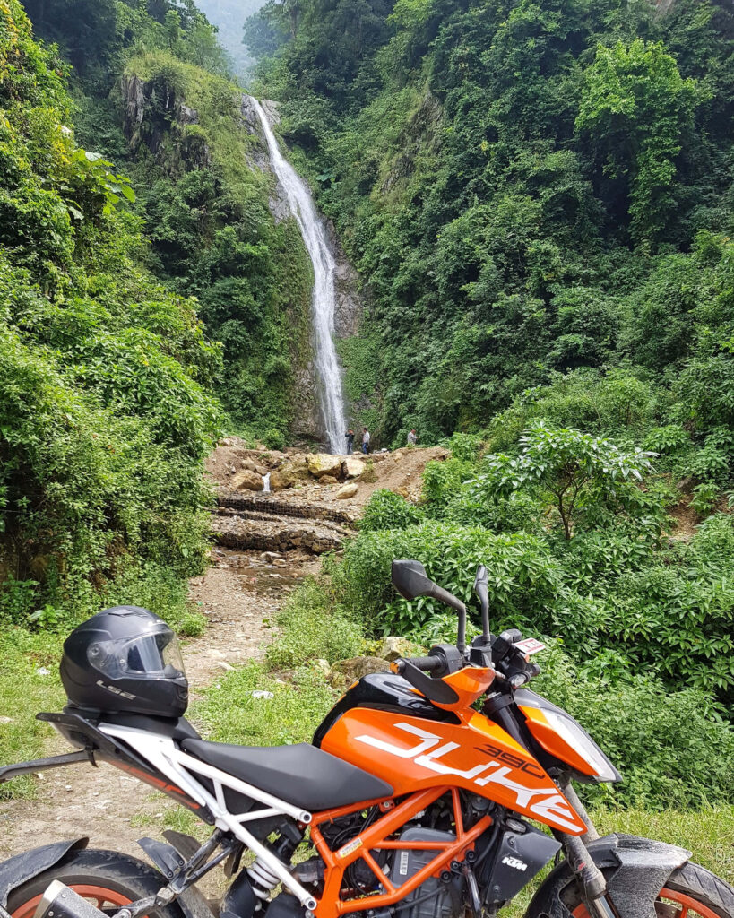 KTM Duke 390 Wallpaper: Adventure Amidst a Lush Waterfall