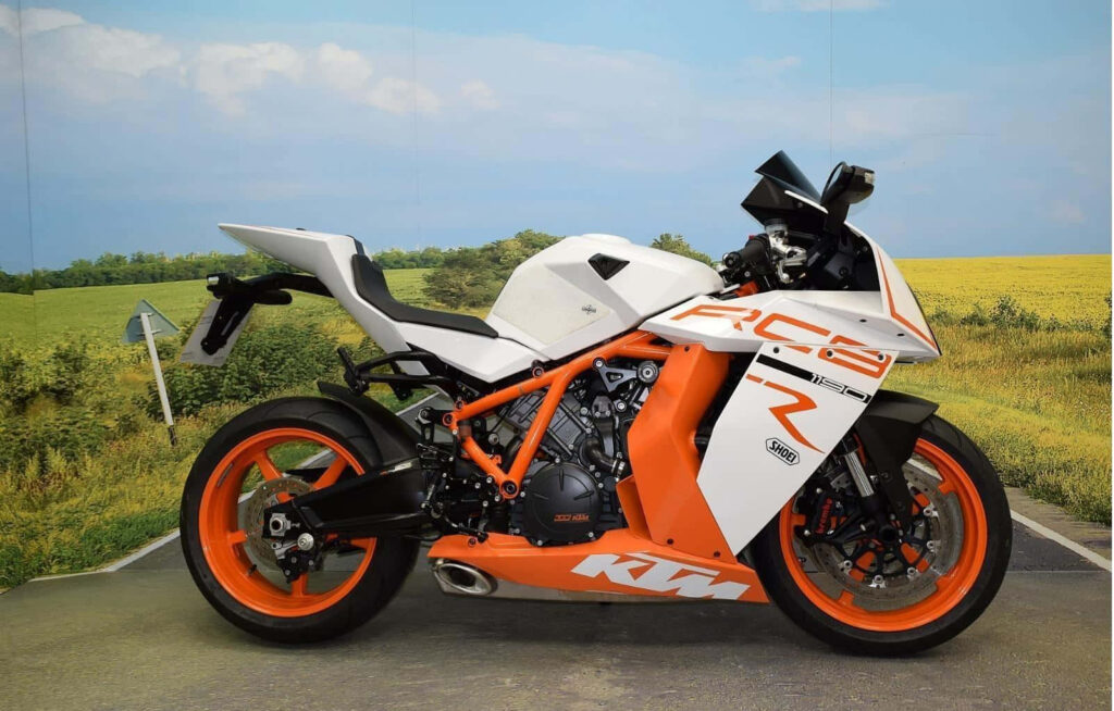 Sleek KTM RC8 R Wallpaper: Dynamic Orange & White Design in Countryside