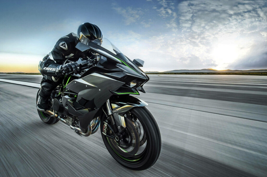 Futuristic Kawasaki H2R Wallpaper: Rider in Motion at Sunset