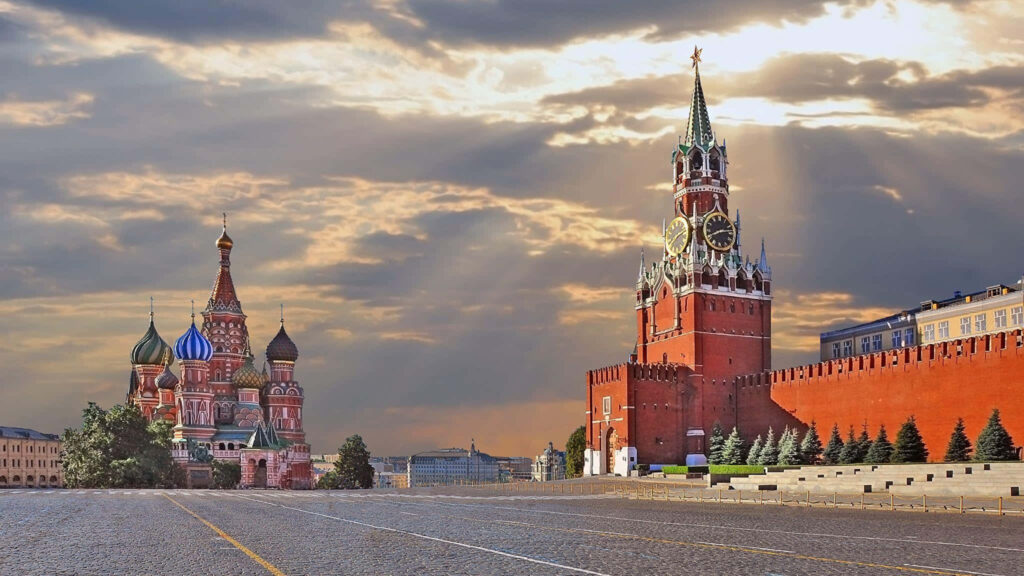Kremlin Moscow with sun rays highlighting St Basils Cathedral and Spasskaya Tower wallpaper