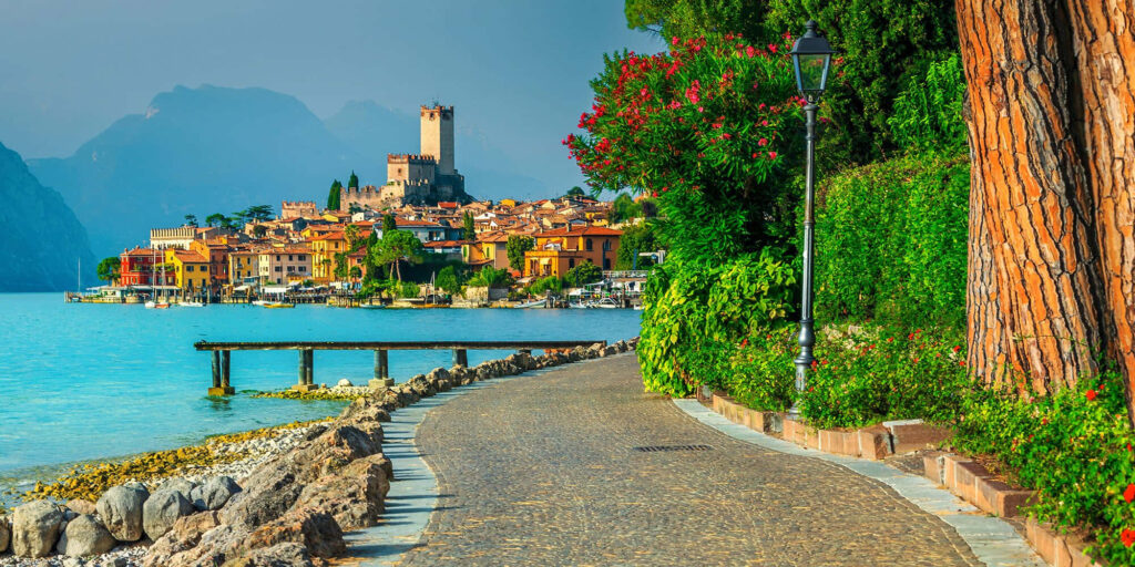 Lakeside Beauty: Lago di Garda with Cobblestone Path & Castle Wallpaper