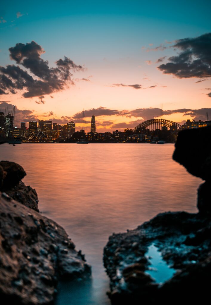 Serene Lakeside Sunset Wallpaper: City Skyline & Bridge Reflection