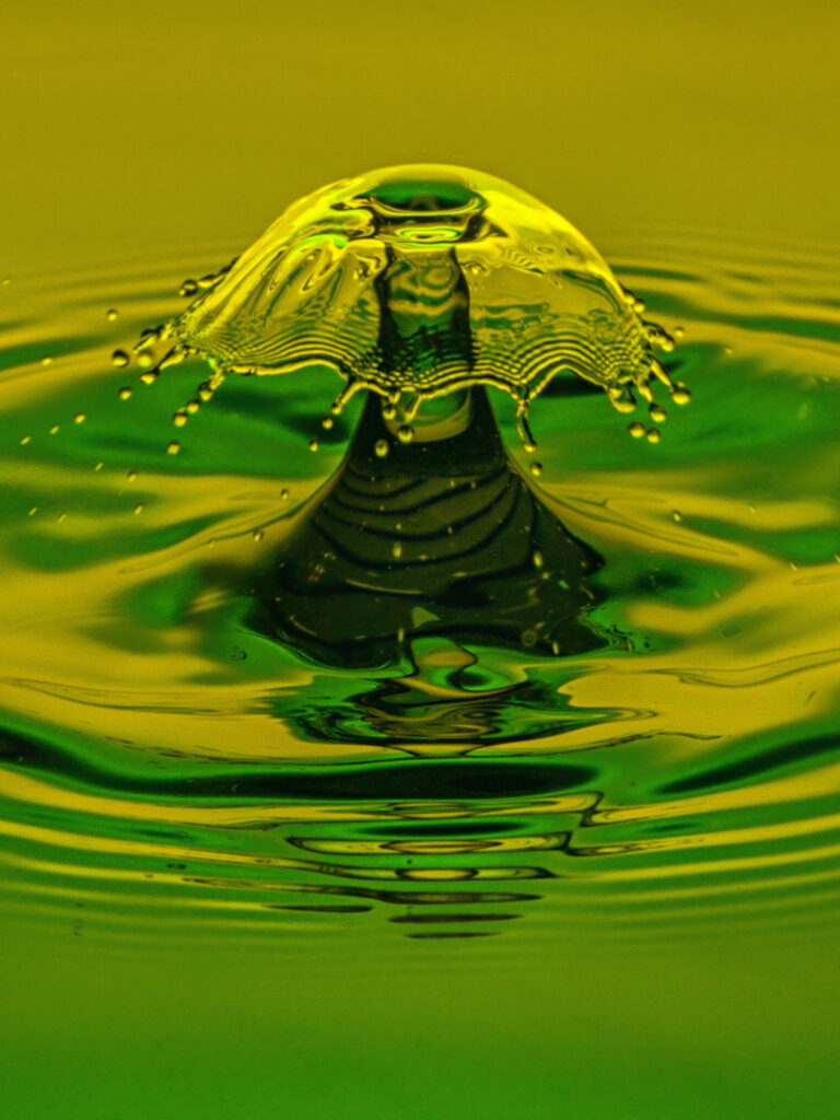 Vibrant Splash Impact: Golden & Green Liquid Drop Macro Wallpaper