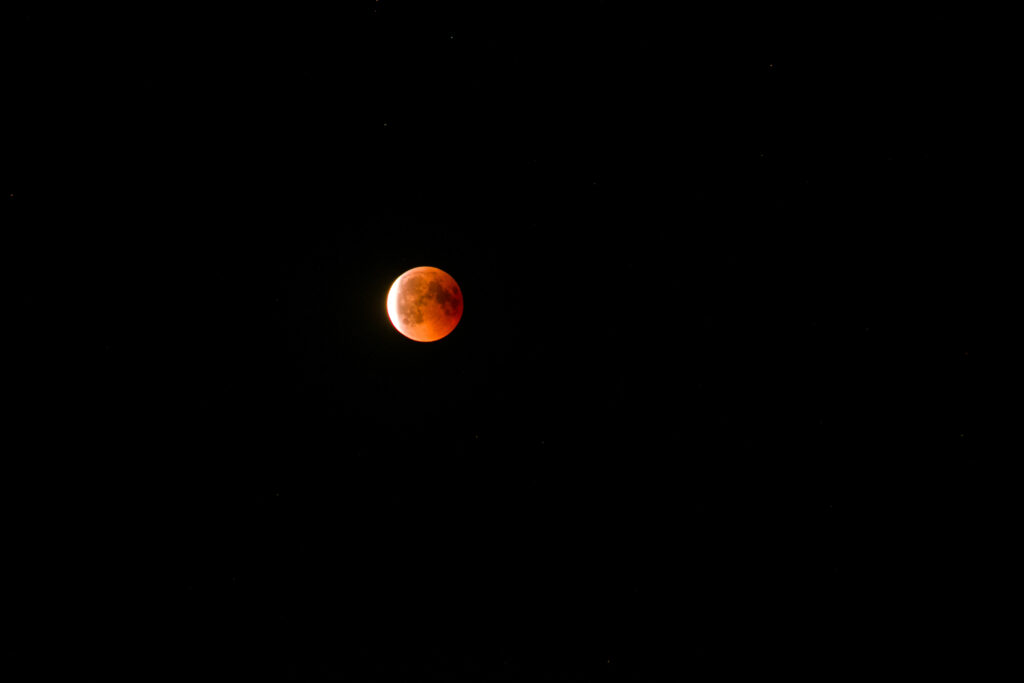 Stunning Lunar Eclipse Wallpaper: Glowing Moon & Dark Galaxy Background