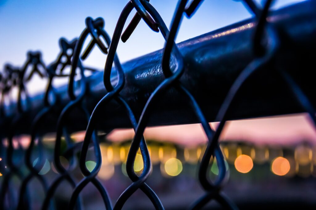 Captivating Macro Metal Mesh Fence with Colorful Bokeh Wallpaper
