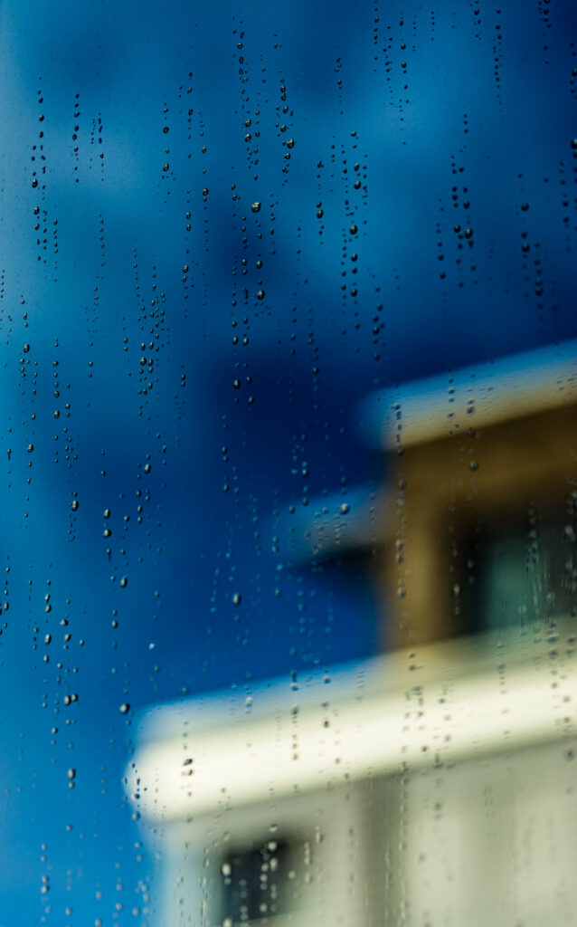 Macro Shot: Water-Dropped Glass View of Blurred Building Wallpaper