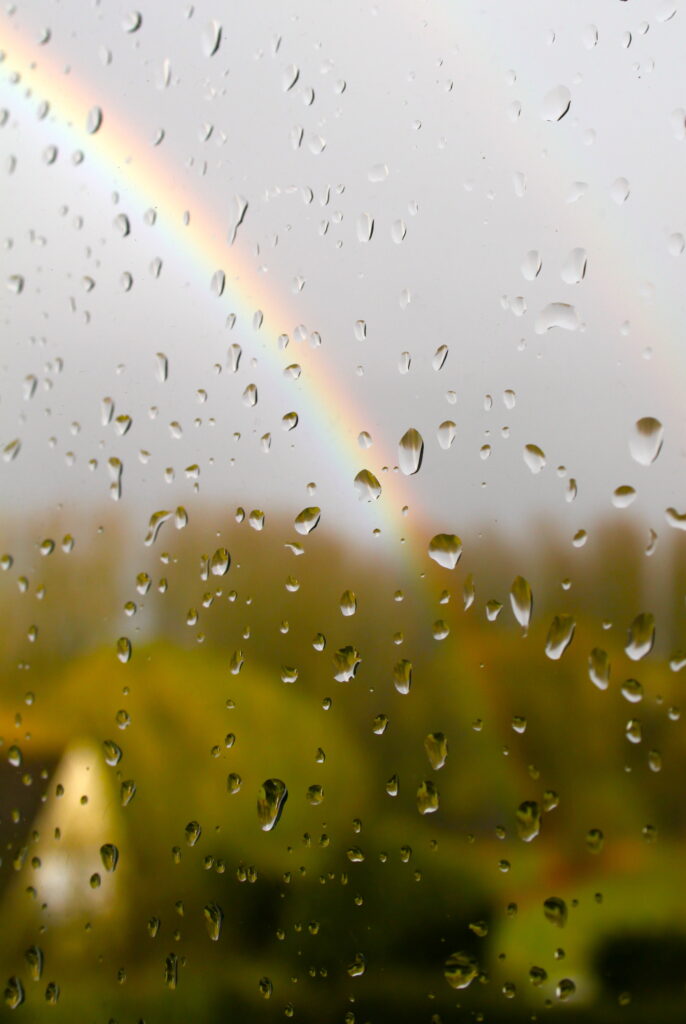 Stunning Macro of Rain Droplets on Glass with Rainbow Wallpaper Background