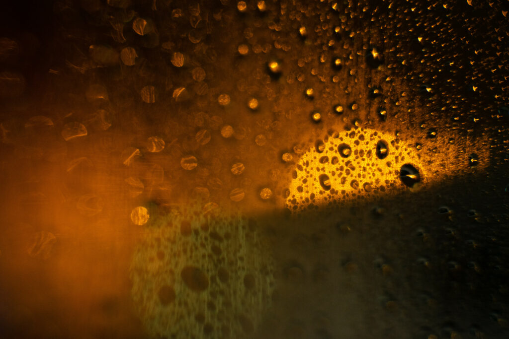 Stunning Macro Wallpaper: Raindrops on Glass with Warm Glow