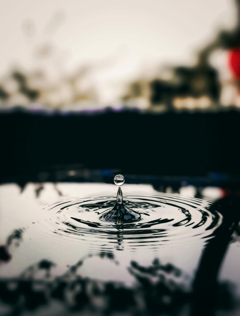 Stunning Macro Wallpaper: Water Drop Creating Ripples & Reflections