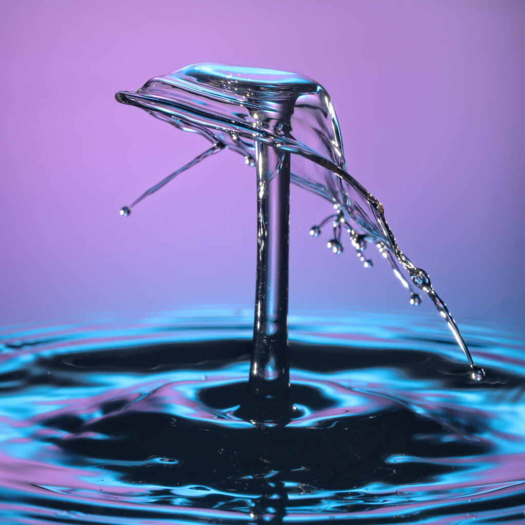 Stunning Macro Wallpaper: Water Droplet Splash with Vibrant Background