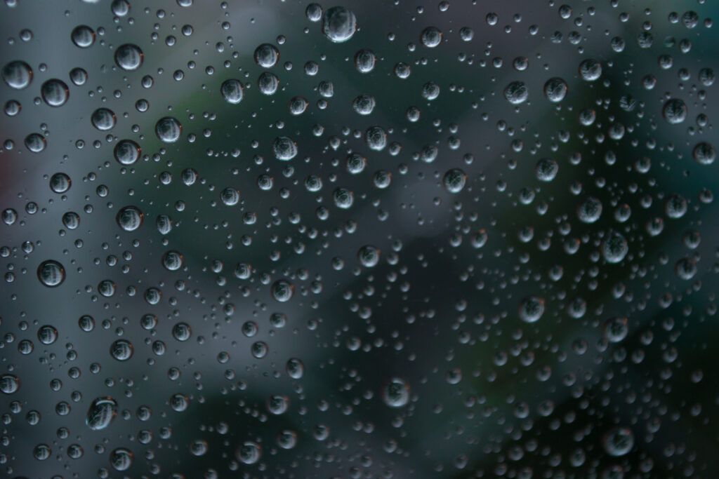 Stunning Macro Wallpaper: Water Droplets on Glass with Nature Blur
