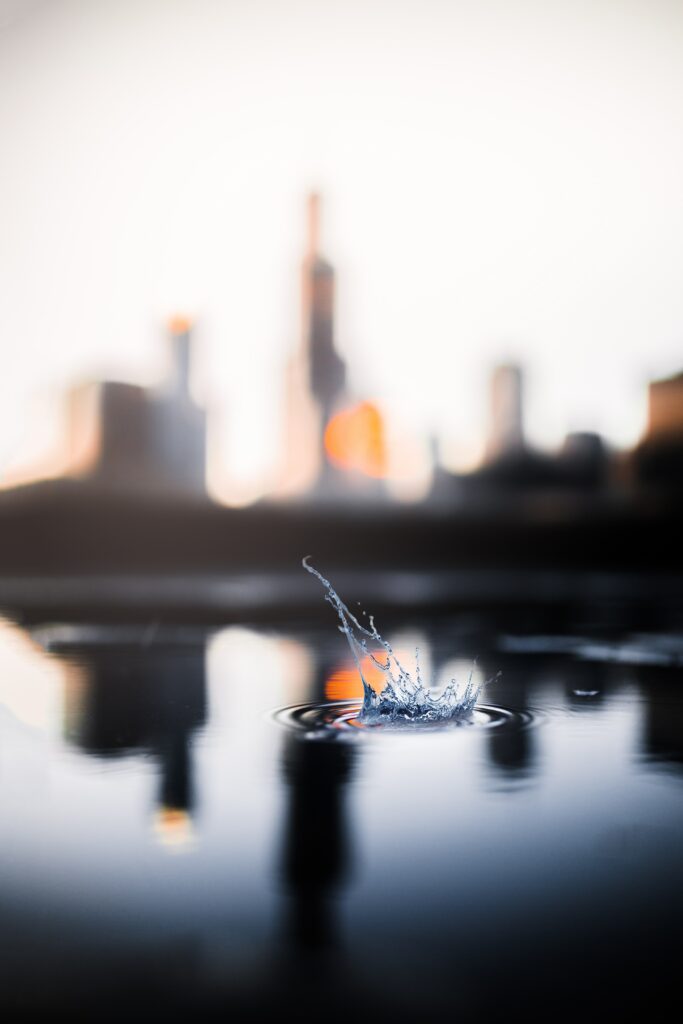 Stunning Macro Water Splash Wallpaper Against Blurred Cityscape