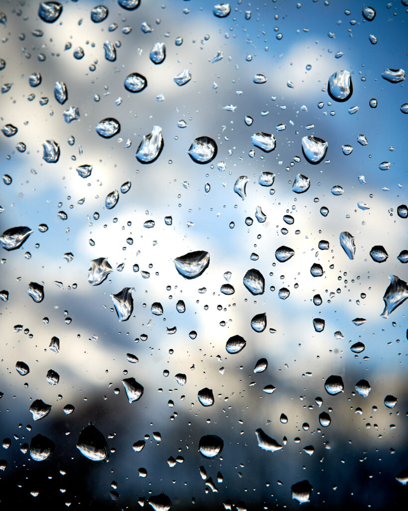 Macro Shot of Water Droplets on Glass: Cloudy Sky Wallpaper