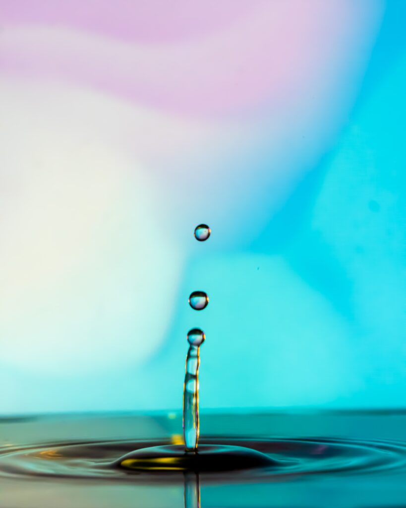 Vibrant Water Drops Mid-Splash: Colorful Gradient Wallpaper