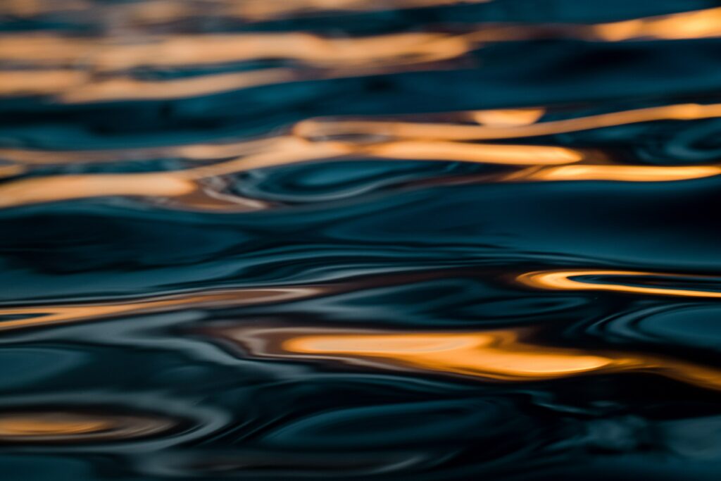 Serene Macro Water Ripples Wallpaper: Golden & Blue Hues