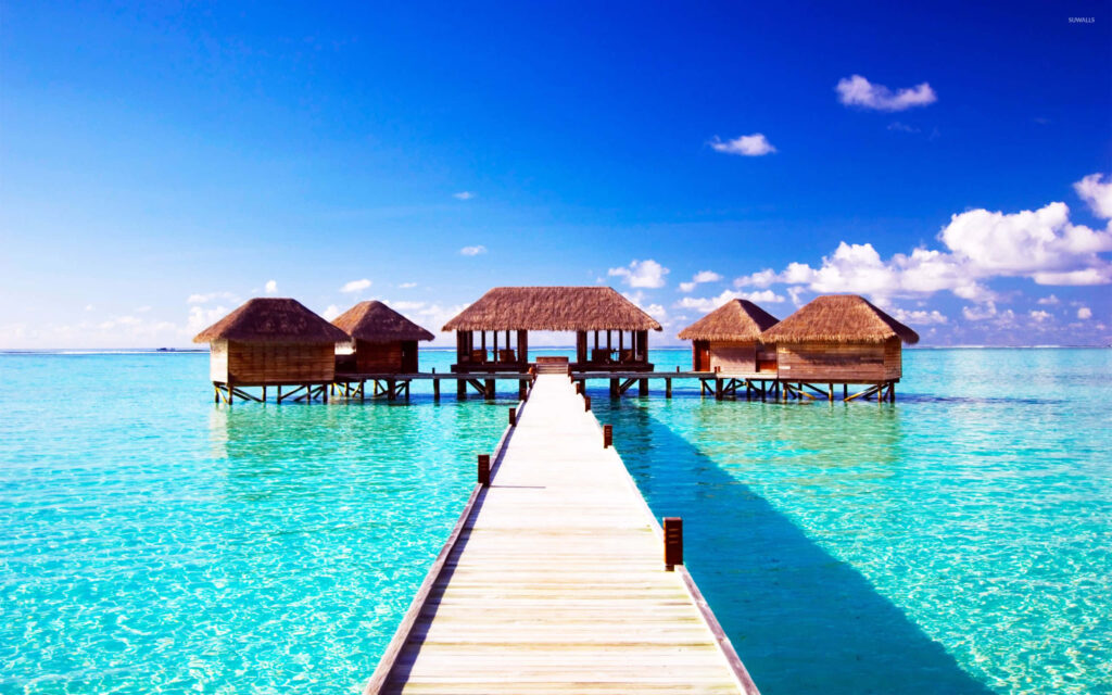 Stunning Maldives Beach: Turquoise Waters & Thatched Huts Walkway Wallpaper