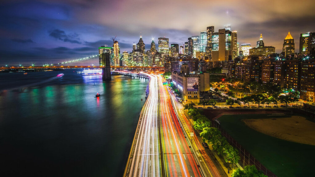 Stunning Manhattan Night View: Vibrant Light Trails & Skyscrapers Wallpaper