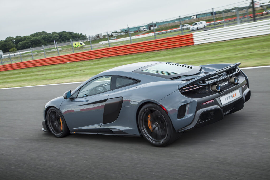 Stunning McLaren 675LT in Motion: Aerodynamic Gray & Orange Calipers Wallpaper