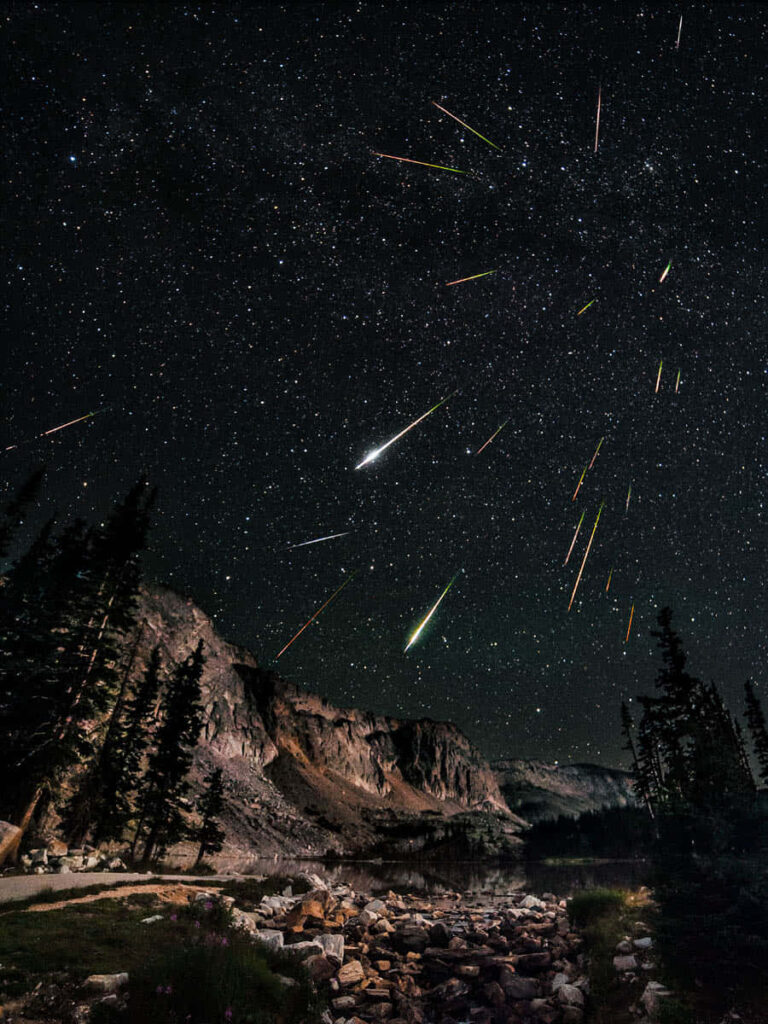 Stunning Night Sky Meteor Shower Over Serene Mountain Lake Wallpaper