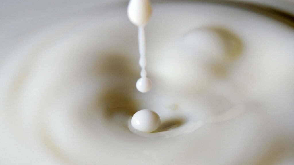 Stunning Milk Droplets Splash Wallpaper: Soothing Liquid Motion