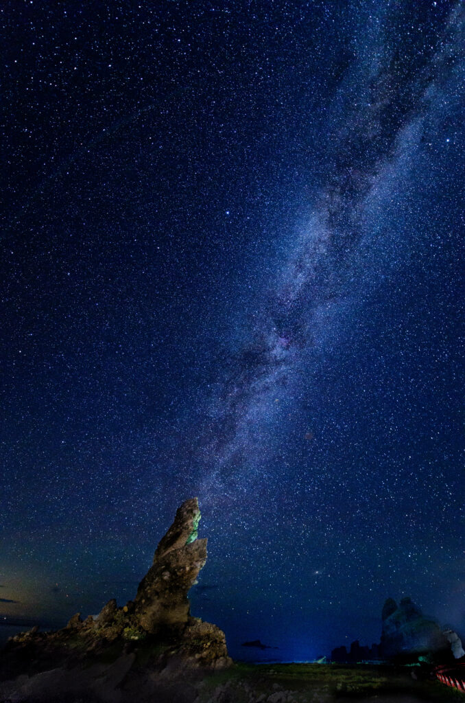 Milky Way over rock formations night sky wallpaper cosmic stars dark blue serene landscape