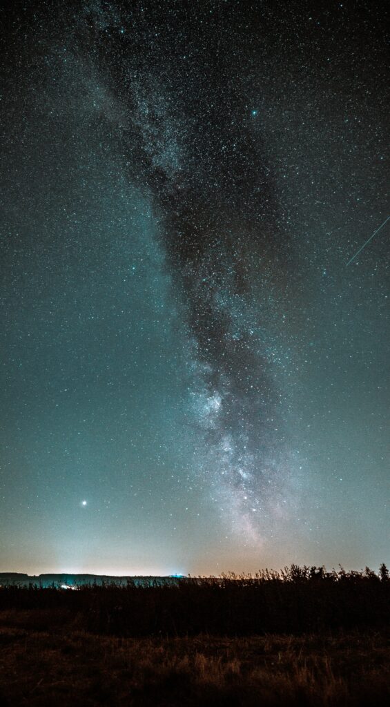 Stunning Milky Way galaxy over serene horizon with starry night sky in deep blue tones wallpaper