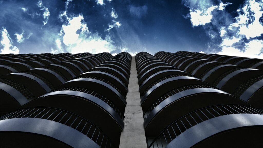 Modern Building Facade Wallpaper: Sleek Curves & Dramatic Sky