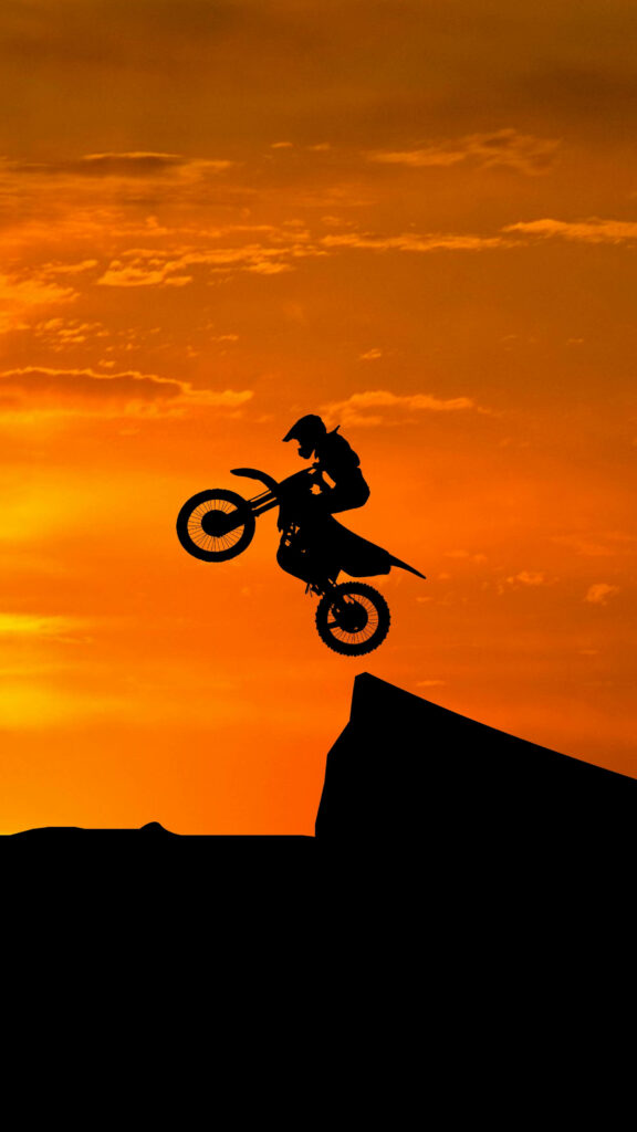Vibrant Motocross Rider Jump Wallpaper - Bold Sunset Background