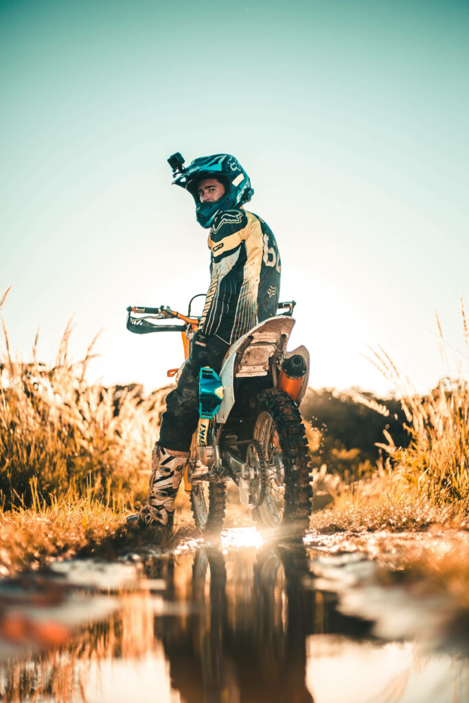 Adventure Wallpaper: Motocross Rider in Sunlit Rugged Landscape