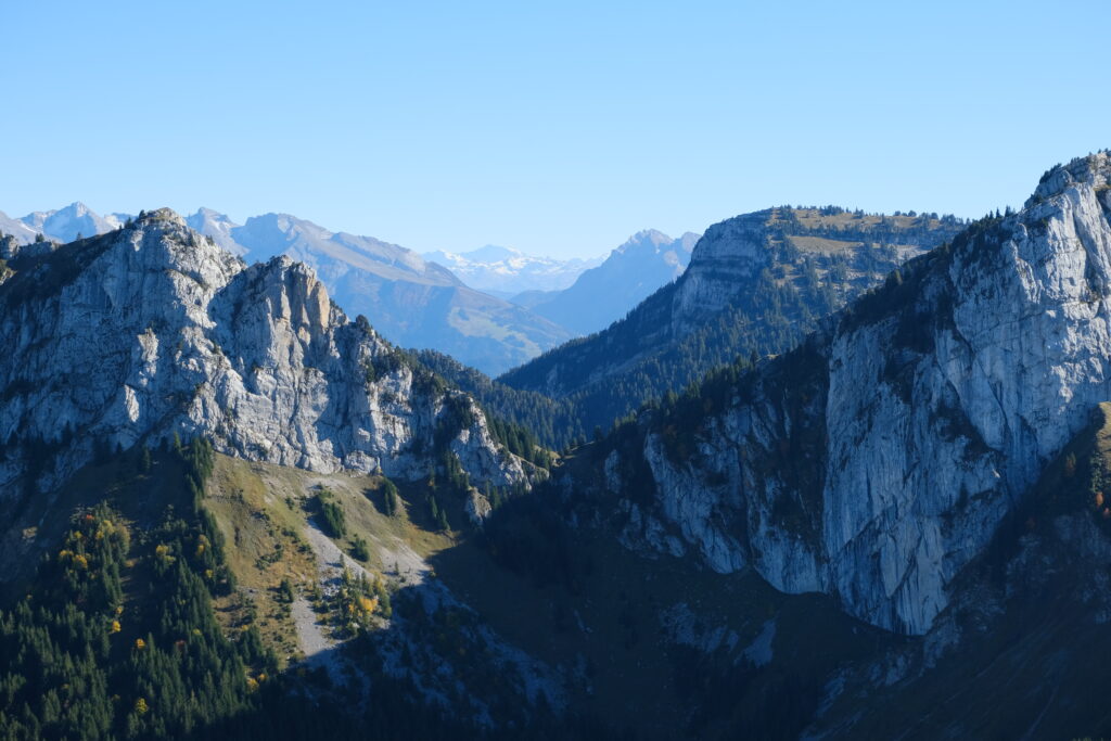Breathtaking mountain landscape with rugged cliffs lush valleys and clear blue sky panorama Wallpaper