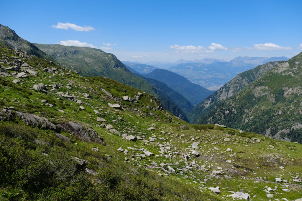 Stunning mountain landscape with green slopes rocky terrain deep valley and clear blue sky wallpaper