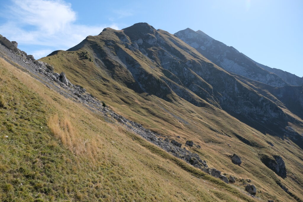 Mountain landscape wallpaper with sharp peaks grassy slopes clear blue sky and natural light