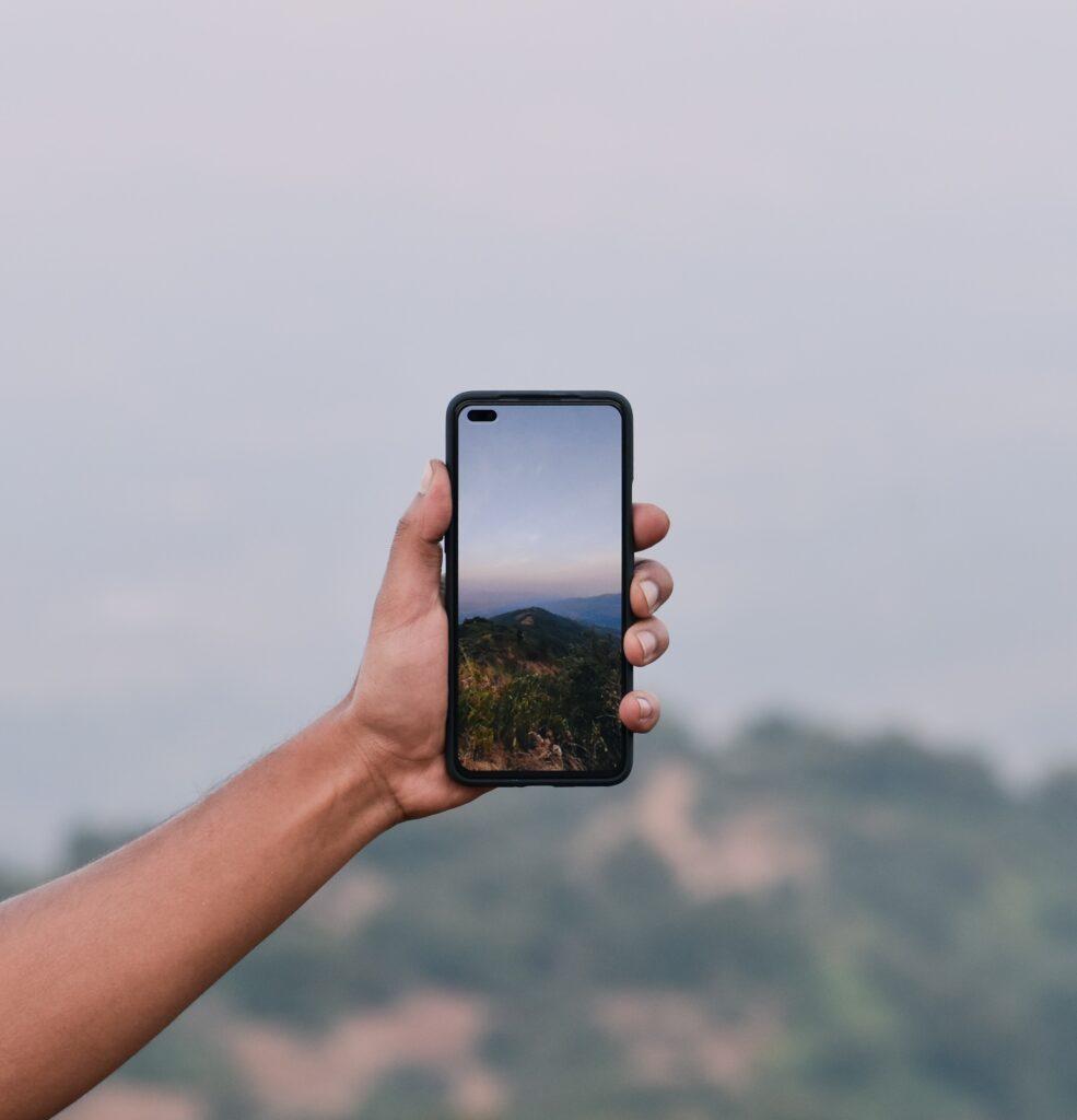 Artistic Wallpaper: Phone Displaying Stunning Mountain View Background
