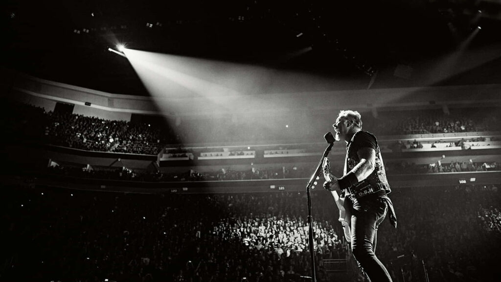 Live Music Performance Wallpaper: Spotlighted Musician in Packed Arena
