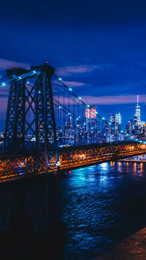 Nighttime NYC Bridge Wallpaper: Vibrant Skyline & Deep Blue Reflections