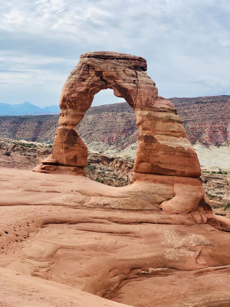Natural stone arch in red desert landscape under clear blue sky scenic geological formation wallpaper