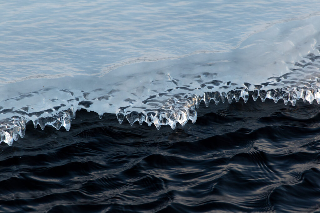 Tranquil Nature Wallpaper: Ice Formations & Dark Rippling Water