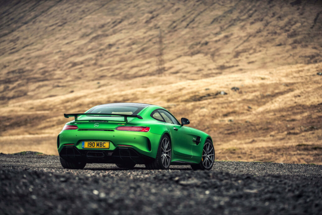 Vibrant Neon Green Mercedes-AMG GT Wallpaper in Rugged Landscape