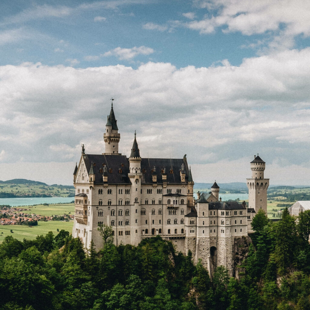 Stunning Neuschwanstein Castle Side View Wallpaper with Lush Greenery