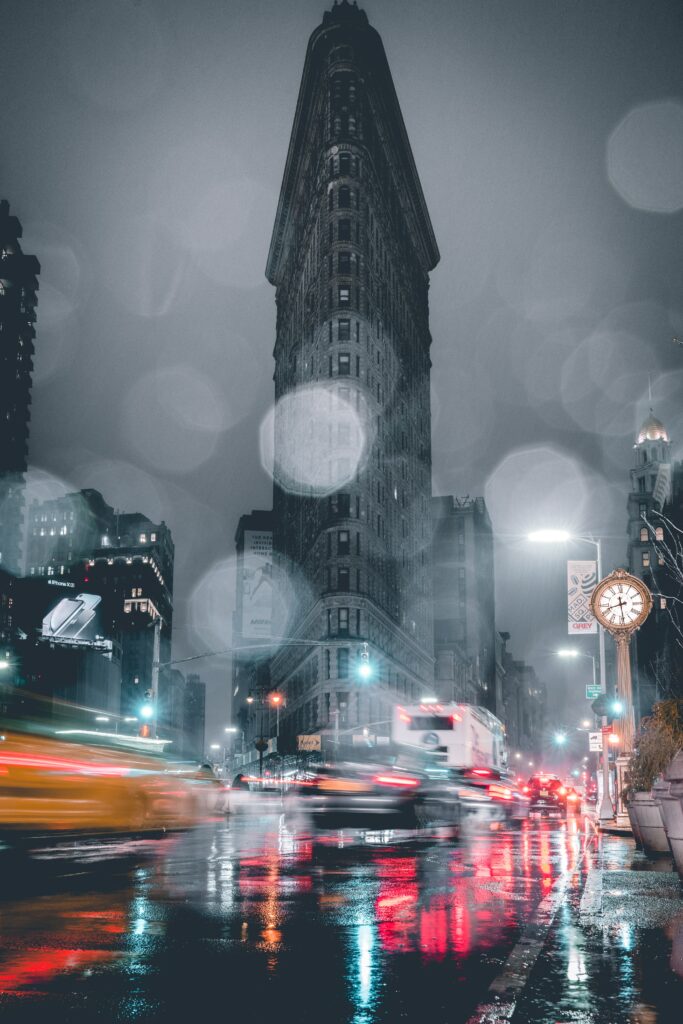 Dynamic Night City Wallpaper: Triangular Building & Vibrant Lights