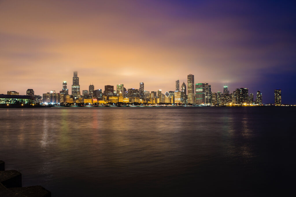 Stunning Night Cityscape Wallpaper: Illuminated Buildings & Calm Sea