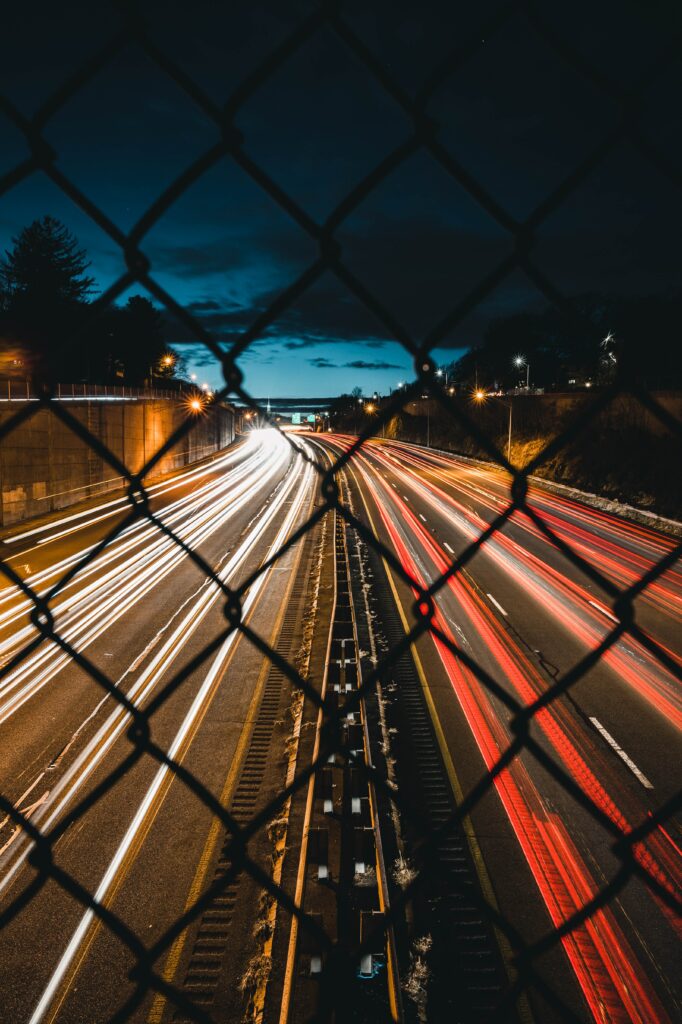 Stunning Nighttime Highway Wallpaper with Light Trails & City Skyline