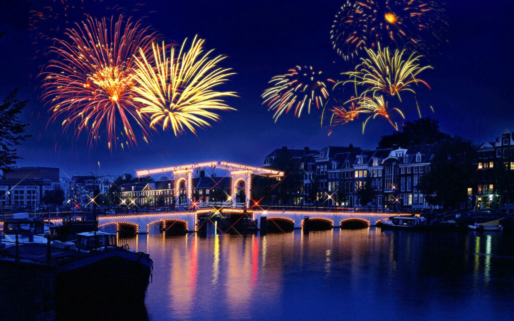 Vibrant Night Scene Laptop Wallpaper: Fireworks & Bridge Reflections