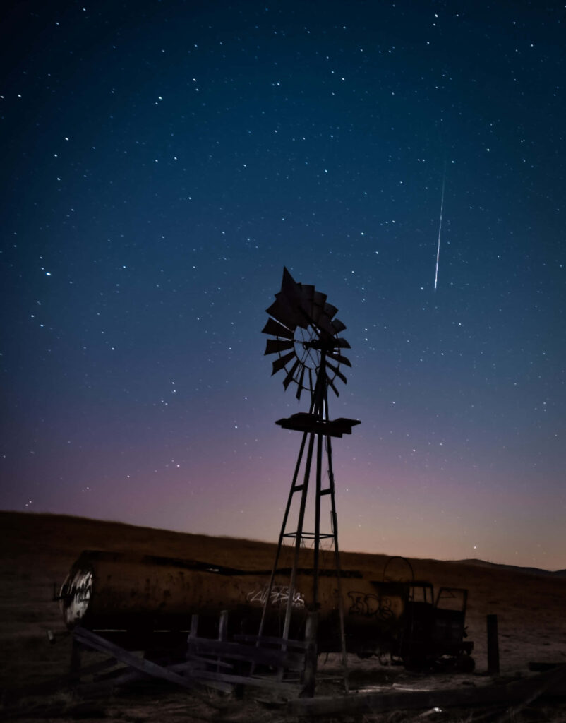 Breathtaking Night Sky Wallpaper with Meteor Shower & Windmill Silhouette